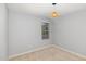 A minimalist bedroom features a large window and a rattan pendant light at 102 Bella Pl, Holly Springs, NC 27540