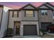 Charming townhome featuring a one-car garage, shutters, and a combination of siding and brick at 102 Bella Pl, Holly Springs, NC 27540
