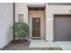 Close-up view of the townhome's front door and entryway with a small window at 102 Bella Pl, Holly Springs, NC 27540