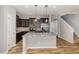 Modern kitchen featuring a large island, stainless steel appliances, and dark wood cabinets at 102 Bella Pl, Holly Springs, NC 27540
