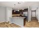 Modern kitchen featuring a large island, stainless steel appliances, and dark wood cabinets at 102 Bella Pl, Holly Springs, NC 27540
