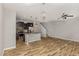 Open-concept living space with wood floors flowing into a modern kitchen with an island at 102 Bella Pl, Holly Springs, NC 27540