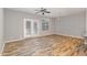 Bright living room with wood floors, glass patio doors, and a modern light fixture at 102 Bella Pl, Holly Springs, NC 27540