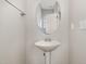 A quaint powder room includes a white pedestal sink, a mirror and chrome fixtures at 102 Bella Pl, Holly Springs, NC 27540