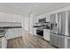 Modern kitchen featuring stainless steel appliances, white cabinetry, and dark countertops at 112 Roping Horn Way, Willow Springs, NC 27592