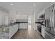 Bright kitchen featuring stainless steel appliances, white cabinets, and stone accented breakfast bar at 112 Roping Horn Way, Willow Springs, NC 27592