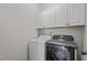 Laundry area with white cabinetry and modern washer and dryer units at 112 Roping Horn Way, Willow Springs, NC 27592
