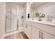 Bright bathroom with double vanity, framed mirror, modern fixtures, and glass-enclosed shower at 1169 Abbott St, Mebane, NC 27302