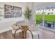 A charming dining room features a round table, six chairs, contemporary art, and a serene view of the outdoors at 1169 Abbott St, Mebane, NC 27302