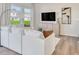 A cozy living room with a plush white sofa, modern furnishings, and large windows offering great views at 1169 Abbott St, Mebane, NC 27302