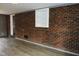 Finished basement with a painted brick wall, a built-in shelf and wood-look flooring at 1212 St. Marys Rd, Hillsborough, NC 27278