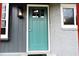 Inviting entrance with a teal front door, white trim, and stylish exterior lighting at 1212 St. Marys Rd, Hillsborough, NC 27278