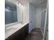 Modern bathroom with double vanity, large mirror, walk-in shower, and wood floors at 1239 Hammond Dr, Mebane, NC 27302