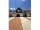 New townhome construction showing diverse exteriors, garage doors, concrete driveways, and blue skies at 1255 Hammond Dr, Mebane, NC 27302