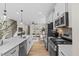 Open concept kitchen and living area with white cabinets, stainless appliances, and hardwood floors throughout at 1255 Hammond Dr, Mebane, NC 27302