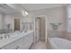 Bright bathroom featuring a double sink vanity, large mirror, and separate tub at 129 Cofield Cir, Durham, NC 27707