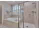 Bathroom showcasing a tiled shower and soaking tub next to shuttered windows at 129 Cofield Cir, Durham, NC 27707