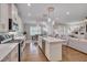 Bright kitchen features stainless appliances, white cabinetry and an island with seating at 129 Cofield Cir, Durham, NC 27707