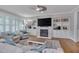 Inviting living room featuring a stone fireplace, built-in cabinets, and large windows at 129 Cofield Cir, Durham, NC 27707