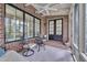 Well-lit sunroom featuring brick walls, a ceiling fan, and elegant French doors at 129 Cofield Cir, Durham, NC 27707