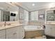 Bathroom with a soaking tub, separate vanities, tile accents, and large window at 1300 Marshall Farm St, Wake Forest, NC 27587