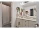 Bright bathroom featuring double sinks, white cabinetry, hanging plants, and modern fixtures at 1300 Marshall Farm St, Wake Forest, NC 27587