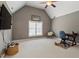 Bedroom with vaulted ceiling, cozy chair, desk and television offers a calm and uncluttered space at 1300 Marshall Farm St, Wake Forest, NC 27587