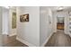 Hallway with wood-look flooring showcases artistic decor, leading to a bedroom with a daybed at 1300 Marshall Farm St, Wake Forest, NC 27587