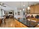 Open kitchen features granite counters, wood cabinets, stainless appliances, and island with pendant lights at 1300 Marshall Farm St, Wake Forest, NC 27587