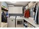 Functional laundry room with washer, dryer, storage cabinets, and hanging rack at 1300 Marshall Farm St, Wake Forest, NC 27587