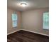 A neutral bedroom is illuminated by natural light from two windows and features wood-look flooring at 132 Waiters Way Way, Youngsville, NC 27596