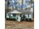 Inviting one-story house boasts a covered front porch and blue shutters nestled among mature trees at 132 Waiters Way Way, Youngsville, NC 27596