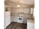 The cozy kitchen features white appliances, cabinets, and gray countertops with stainless steel sink at 132 Waiters Way Way, Youngsville, NC 27596