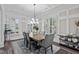 Elegant dining room featuring a coffered ceiling, plantation shutters, wood floors, and modern chandelier at 1332 Gloriosa St, Apex, NC 27523
