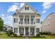 Stunning two-story home featuring a grand front porch with classic white columns and manicured landscaping at 1332 Gloriosa St, Apex, NC 27523