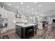 Bright, open kitchen boasts white cabinets, a large island with seating, and stainless steel appliances at 1332 Gloriosa St, Apex, NC 27523