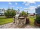 Outdoor grill area with stone surround in a landscaped backyard, ideal for summer cookouts at 1332 Gloriosa St, Apex, NC 27523