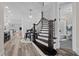 Elegant curved staircase with dark wood treads and a view into the adjacent bathroom at 1332 Gloriosa St, Apex, NC 27523