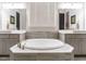 Luxurious bathroom with a large soaking tub, double vanities, and neutral tile accents at 136 Glenpark Pl, Cary, NC 27511