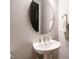 Close-up of a pedestal sink and oval mirror in a half bathroom at 136 Glenpark Pl, Cary, NC 27511