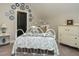 Charming bedroom features a white iron bed frame, decorative plates, and white painted dressers at 136 Glenpark Pl, Cary, NC 27511