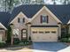 Charming home featuring a brick facade, arched entry, attached garage, and manicured landscaping at 136 Glenpark Pl, Cary, NC 27511