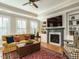 Comfortable living room with fireplace, built-in shelving, and a ceiling fan at 136 Glenpark Pl, Cary, NC 27511