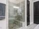 Nicely tiled walk-in shower with glass enclosure, bench, and river rock floor in an elegant bathroom at 136 Glenpark Pl, Cary, NC 27511