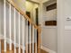 View of a staircase featuring a wooden handrail and white balusters in a bright foyer at 136 Glenpark Pl, Cary, NC 27511