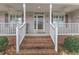 Inviting front porch with brick steps, white railings, and sidelights highlighting the home's entrance at 1410 Briardale Ln, Durham, NC 27712