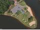 Overhead shot of a lakeside park featuring a sandy beach, mini golf course, and picnic facilities by a serene lake at 1429 Sagamore Dr, Louisburg, NC 27549