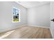 A sunlit bedroom featuring light hardwood floors, neutral walls, and a large window with a bright view at 1429 Sagamore Dr, Louisburg, NC 27549