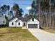 Charming new construction home with board and batten siding, a dark roof, and a long driveway at 1429 Sagamore Dr, Louisburg, NC 27549