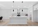 A bright kitchen featuring an island with a sink, white cabinets, and pendant lighting at 1429 Sagamore Dr, Louisburg, NC 27549